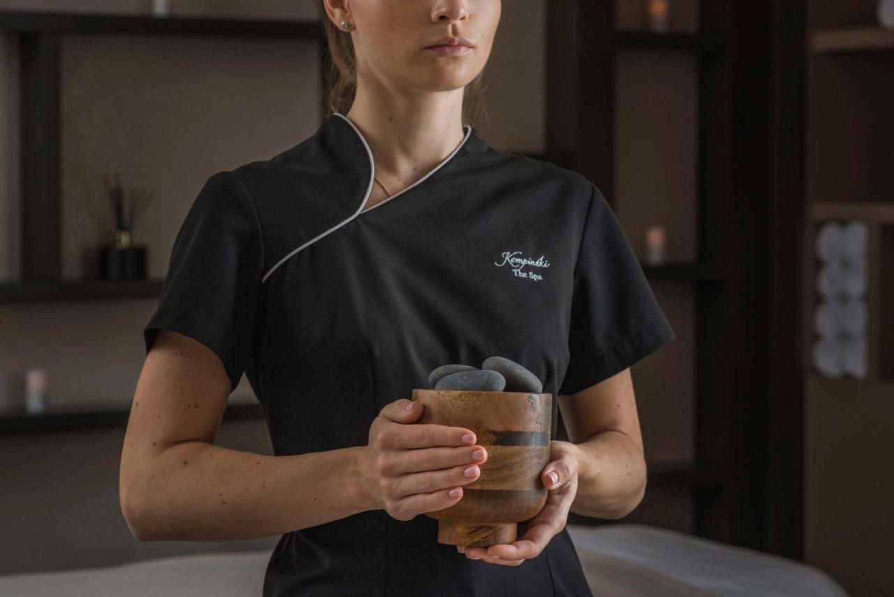 Grand Hotel Kempinski Riga Kültér fotó A spa employee holding a glass of tea